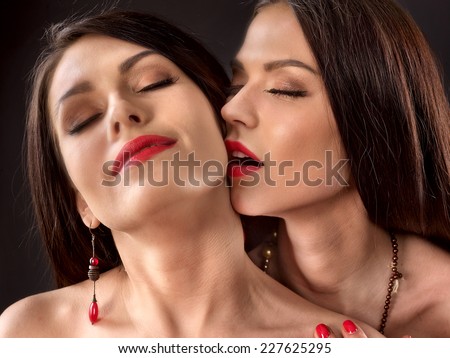 Two kissing lesbian women kissing .Black background.