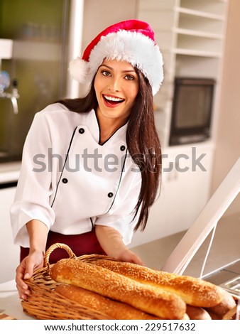 Female chef in Santa hat baking baguette bread.