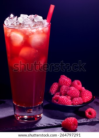 Red raspberry drink  with ice cube and plate of berry on black background. Cocktail card 18