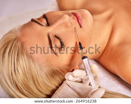 Doctor woman giving botox injections. Visible hand.