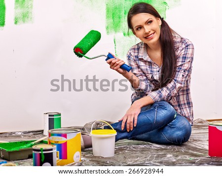 Happy woman paint wall at home