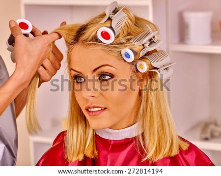 Happy woman wear hair curlers on head in barbershop.