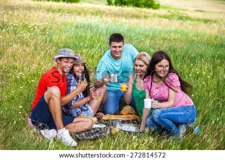 Group people male and female on picnic. Rain drop. Green grass.