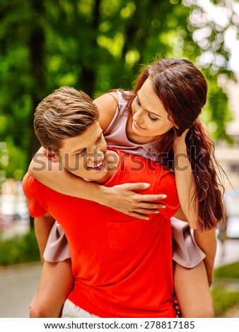 Couple  in orange t-shirt embracing at park. Summer outdoor.
