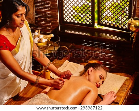 Young woman lying on stomach having oil Ayurveda spa treatment.