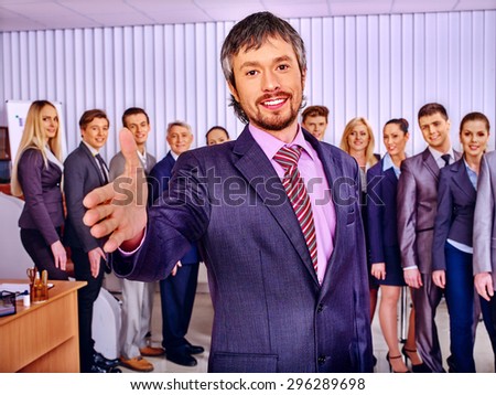 Happy group business people together  in office. Man reaches out.