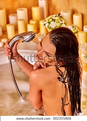 Young woman take shower in bubble  bath.