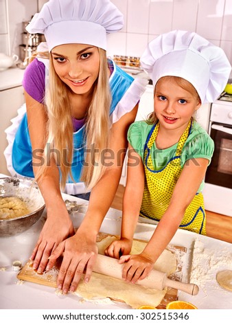 Mother and happy daughter baking cookies.