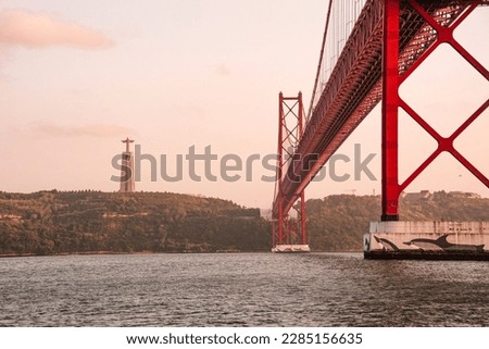 Foto Bild Ponte 25 de Abril Brücke in Lissabon während Sonnenuntergang mit Schiff und Jesus-Denkmal, bewölkten Himmel portugal