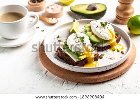 Sandwich with avocado and Poached Egg. Wholemeal Bread Toast sliced avocado and egg with cup of coffee for healthy breakfast or snack, copy space.