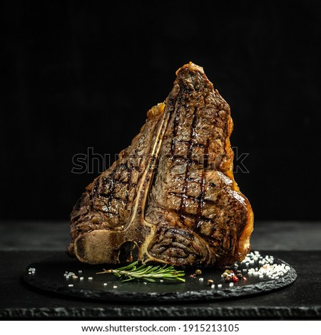 Dry Aged Barbecue Porterhouse Steak T-bone beef steak sliced with large fillet piece with herbs and salt. American meat restaurant. square image,