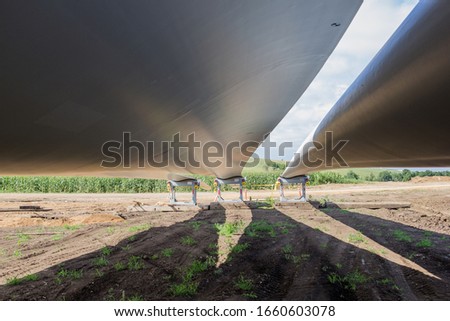 Similar – Image, Stock Photo Long shadow under windmill, large wind power turbines spinning to generating clean, green, renewable energy