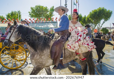 SEVILLE, SPAIN-MAY 8: People mounted on horse on fair of Seville on May 8, 2014 in Seville.