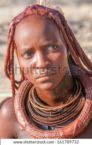 KAOKOLAND,NAMIBIA - OCTOBER 2,2012 - Himba woman decorated with products offered for sale.Women hair painted with a layer of clay loam.Himba is an ethnic group living in northern Namibia.