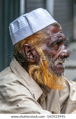 COLOMBO, SRI LANKA - NOVEMBER 10,2011 - Old man sitting in front of mosque.Some men stained beard in ruddy.