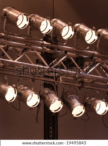 A bank of lit stage lights, or spotlights, for theater, entertainment, or indoor sporting events.