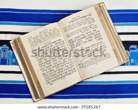 A Jewish prayer book, or Siddur, open and on top of a Jewish prayer shawl or Tallit.