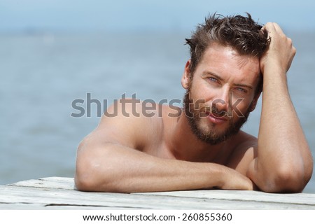 Close up Portrait of Smiling Gorgeous Handsome Man with No Shirt Posing at the Sea