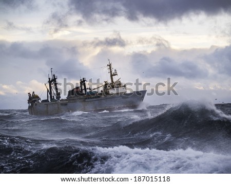 Fishing ship in strong storm. Sunrise.