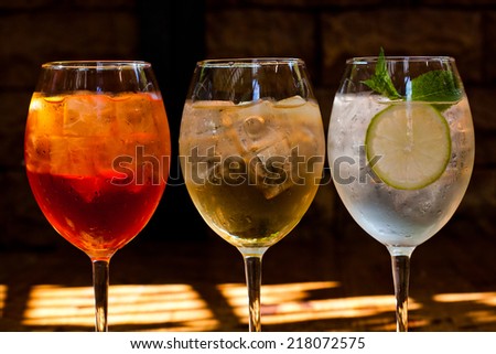 Cocktails: aperol spritz, sprizz (spriss), Martini royale. (dark background). Sparkling wine. Champagne. Sunshine lights and shadows.