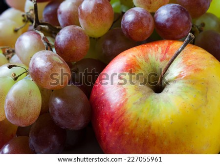 Apple and grapes closeup. Fruit set: red apple and and purple grape.