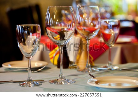 Service: table in a restaurant with a tablecloth, napkins, wine glasses and cutlery.
