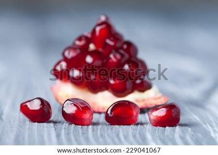 Pomegranate seeds. Part of pomegranate fruit. old gray wooden background. Macro view. (Soft focus).