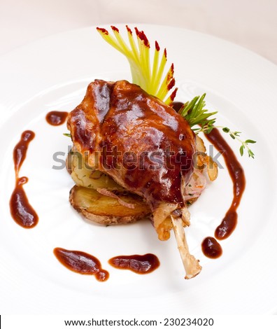 Roasted duck leg. Duck pestle with potato and garlic-bacon sauce. White plate. Duck confit.
