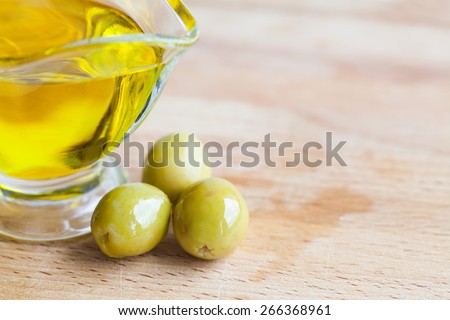 Olives and olive oil jug. cutting board background. Soft focus