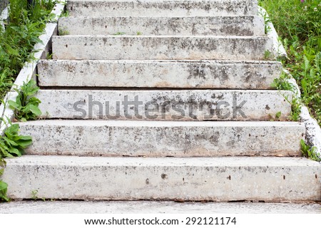 Aged grey stone stairway. stepping stones. side view, summer. day light. soft focus, grass background