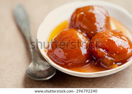 Peach, nectarine, apricot jam in white plate. vintage paper background, aged spoon. soft focus
