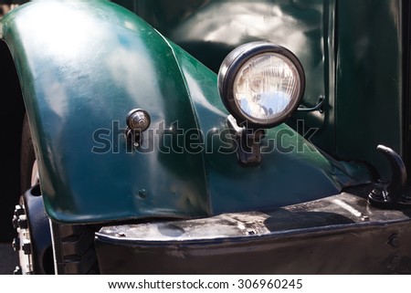 Oldtimer, vintage truck. Dark green color auto parts, vintage design headlight. Ancient lamps, lights. soft focus.