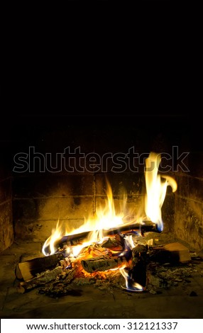 Holidays relaxation concept.Spurts of flame in chimney place. fireplace, resting card template. Evening time. Fiery. Flames of fire. Realistic, beauty fire. Black background, copy space.
