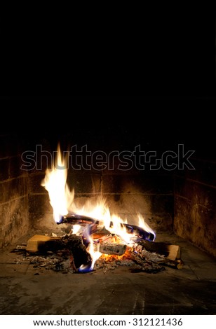 Christmas rest background. Mantelpiece interior. hearth and home. red-hot, forks of flame. Black background, copy space.