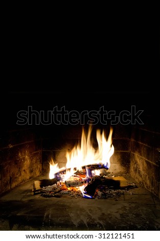 Relaxing at the fireplace on winter evening. Hearth place christmas postcard template. flaming, flames of fire. Black background. Realistic fire. Black background, copy space.