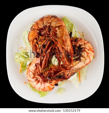 Shrimps and lettuce appetizer isolated on black background