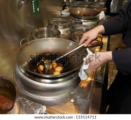 Doughnuts being fried in oil in wok pan, asian restaurant