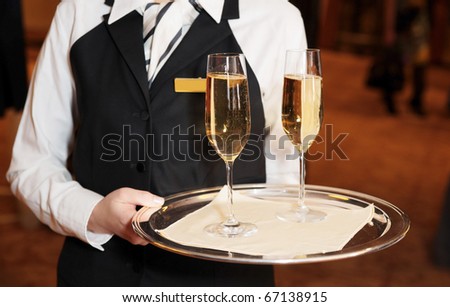 Female waiter welcomes guests with sparkling wine