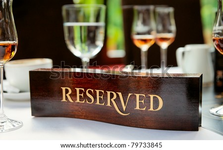 Wooden reserved plate on an arranged restaurant table