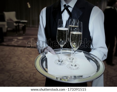 Waiter welcomes guests with champagne