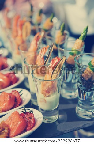 Glasses with seafood snacks -  banquet dish, toned image