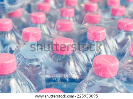 Pink screw cap of  water bottles in plastic wrap