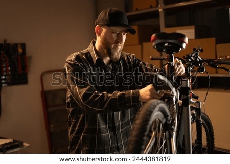 Similar – Image, Stock Photo Bearded mechanic repairing wheel of bicycle