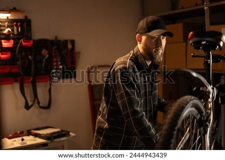 Similar – Image, Stock Photo Bearded mechanic repairing wheel of bicycle