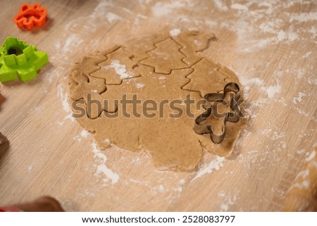 Similar – Image, Stock Photo Gingerbread cookies dough cut in different shapes on a blue table. Baking Christmas cookies