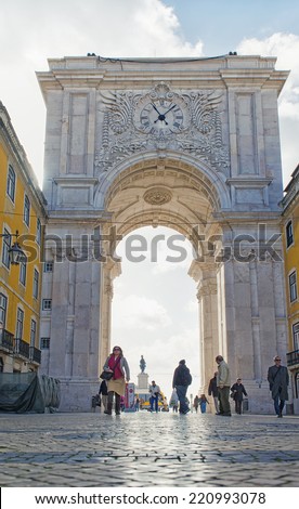LISBON, PORTUGAL - FEBRUARY 3: People walk under The Rua Augusta Arch, a stone triumphal arch-like historical building on February 3, 2014 in Lisbon