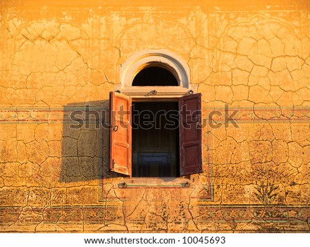 Arched window with shutters in decorated wall of ancient Palace in Rajasthan, India