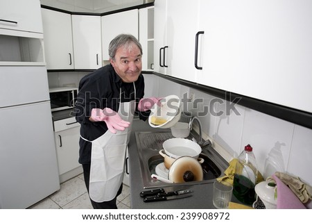 Man cleaning the dishes in the kitchen sink
