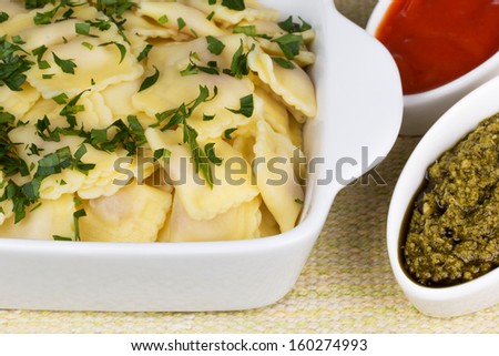 Italian pasta, ravioli with parsley, pesto sauce and tomato sauce