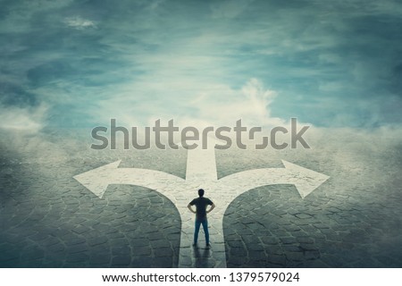 Confident man, hands on hips, stands in front of a crossroad with road split in three different ways as arrows. Choosing the correct pathway between left, right and front. Difficult decision concept. Stock foto © 